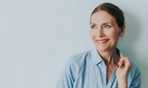 close up of smiling woman in blue blouse