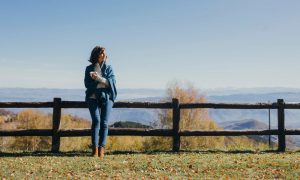 woman standing next to fence outside